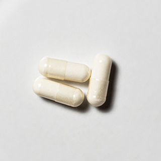White vegan neotes GlyNAC capsules in close-up on a light background