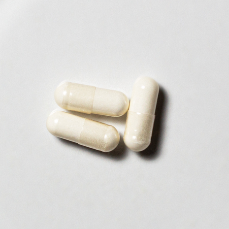 White vegan neotes GlyNAC capsules in close-up on a light background