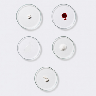 Ingredients of the neotes Harmony Bundle as powder samples, capsules and oil drops in Petri dishes on a light laboratory table
