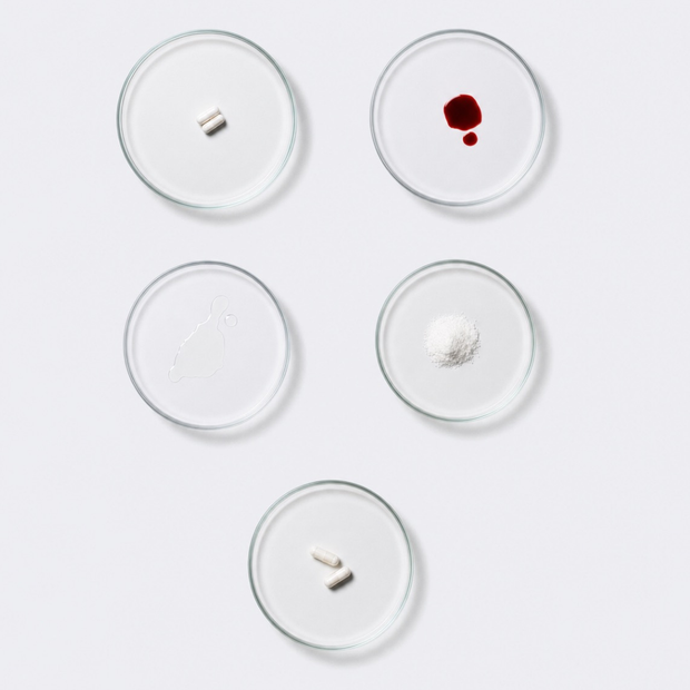 Ingredients of the neotes Harmony Bundle as powder samples, capsules and oil drops in Petri dishes on a light laboratory table