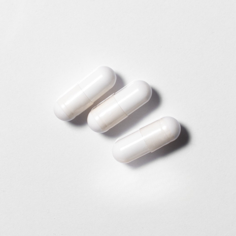 White vegan neotes NMN capsules in close-up on a light background