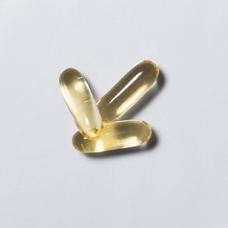Yellow neotes omega-3 softgel capsules in close-up on a light background