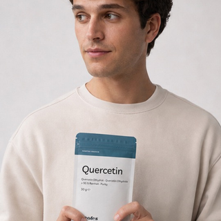 Man holding a neotes pouch of quercetin powder against a light background