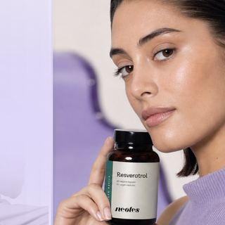 Woman holding neotes resveratrol capsules in her hand for dosing