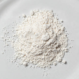 Fine white resveratrol powder in close-up on a light, minimalist background