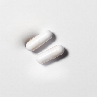White vegan resveratrol capsules in close-up on a light background